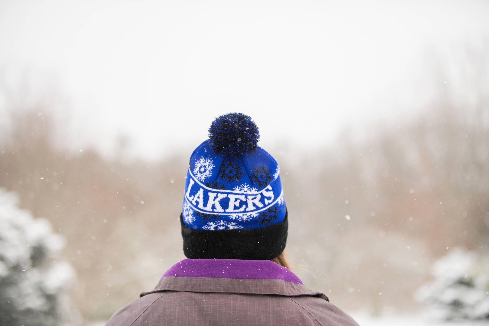 GVSU Student snowshoeing with a GVSU Lakers winter hat on head